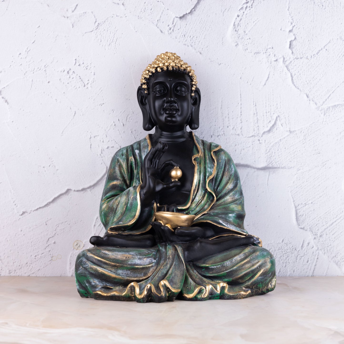 Meditating Buddha statue with pearl in hand